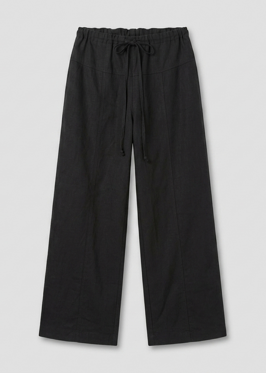 The Seam Pant - Black features a comfortable fit, wide-leg design, elastic waist with drawstring, and is shown flat on a light gray background.