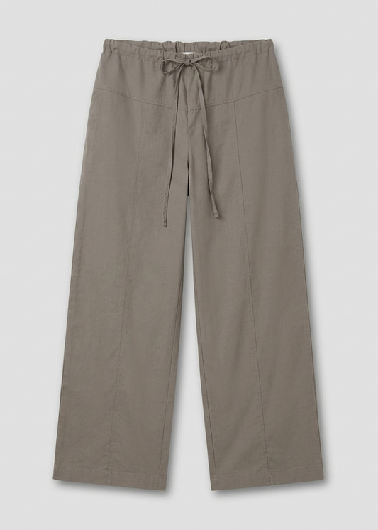 The Seam Pant - Light Khaki by Deiji Studios is a wide-leg, relaxed-fit pant with an elastic waistband, drawstring tie, and visible front seams, displayed flat against a plain light background.