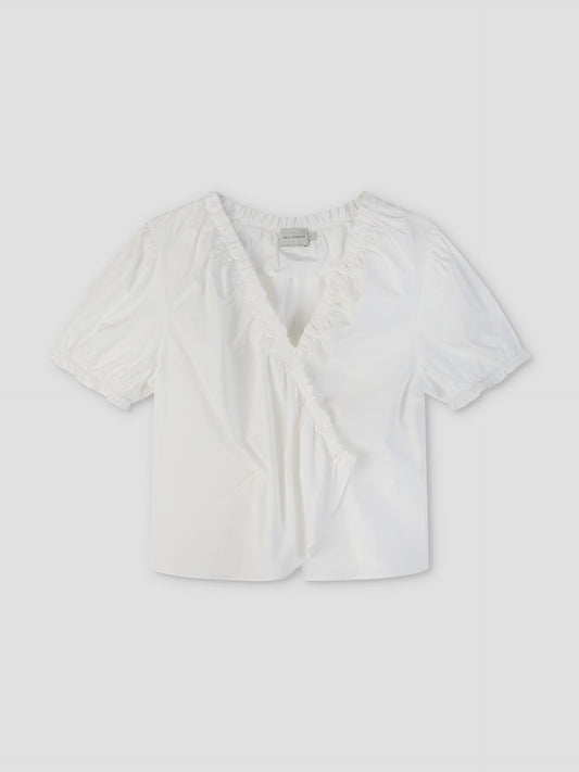The Cross Frill Top - White features short sleeves, a V-neckline with ruffle trim, a buttoned wrap front, and a cropped relaxed fit in crisp fabric for effortless style.