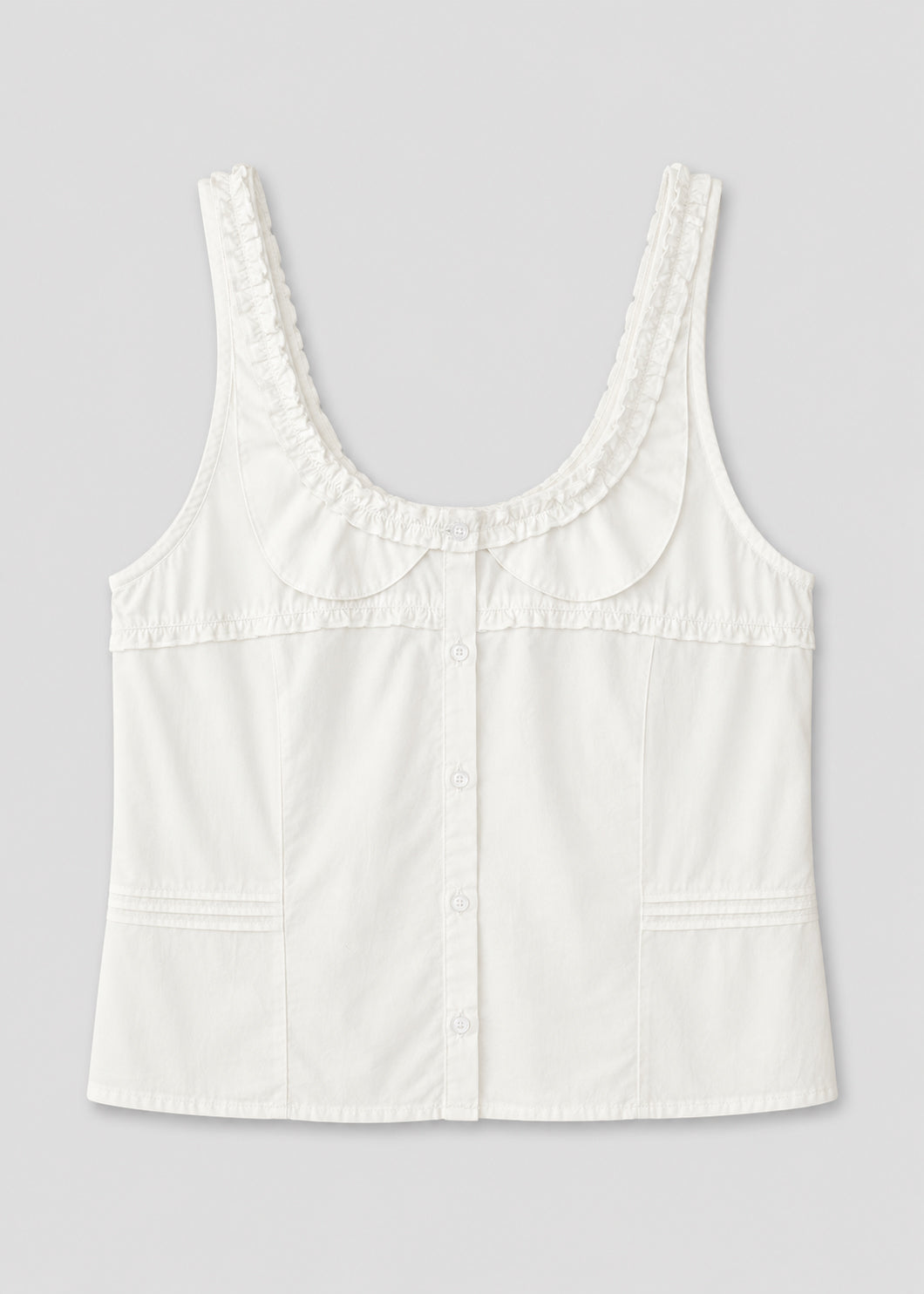 The Frills Top - White is a sleeveless cotton poplin blouse featuring a scooped neckline, ruffled frill trim on the collar, subtle vertical seams, and a fitted silhouette that captures Deiji Studios' signature elegance.