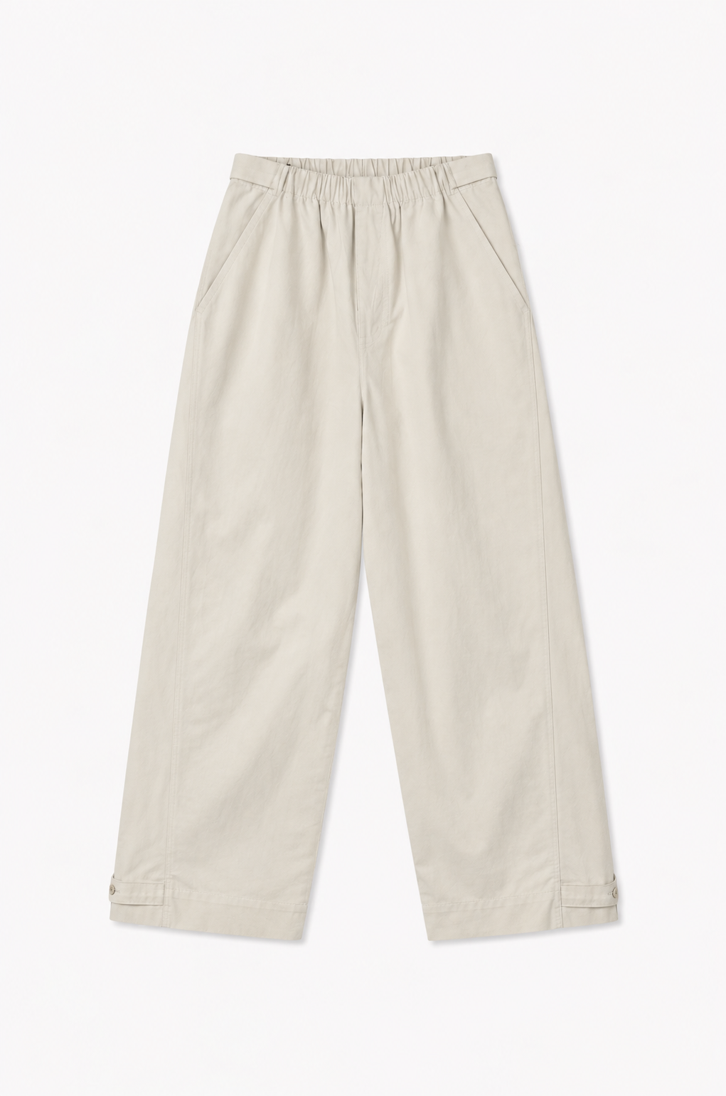 The Snap Tab Pant - Stone by Deiji Studios laid flat against a plain white background, a relaxed wide-leg pant in stone with an elasticated waistband, side pockets and adjustable snap tabs at the hem.