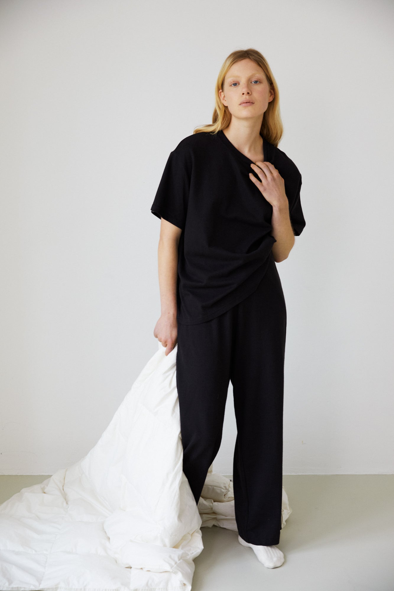 Female model wearing the jersey pant - black by Deiji Studios against plain background