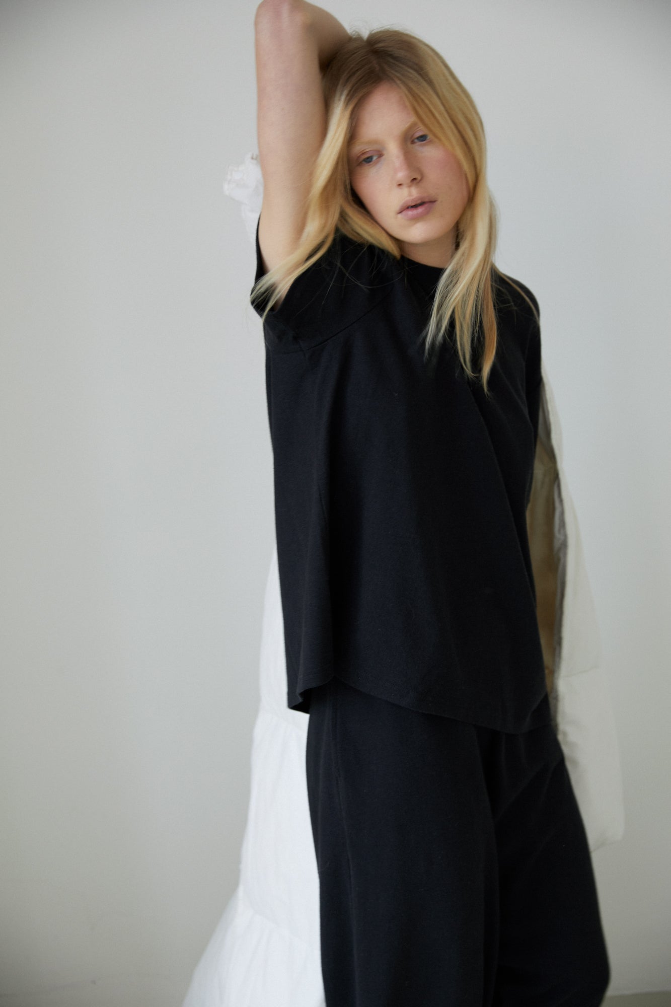 Female model wearing the jersey pant - black by Deiji Studios against plain background