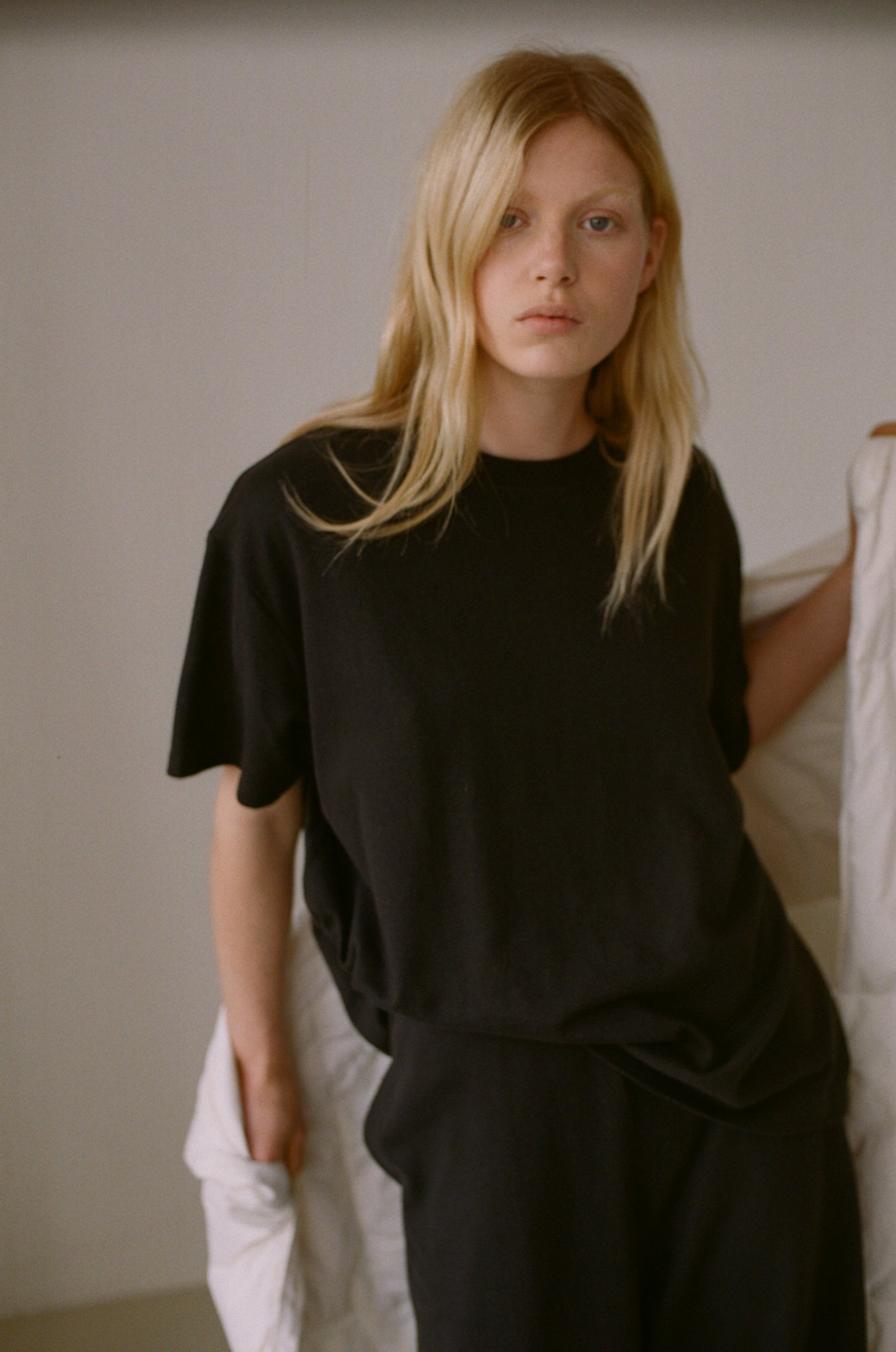 Female model wearing the jersey pant - black by Deiji Studios against plain background