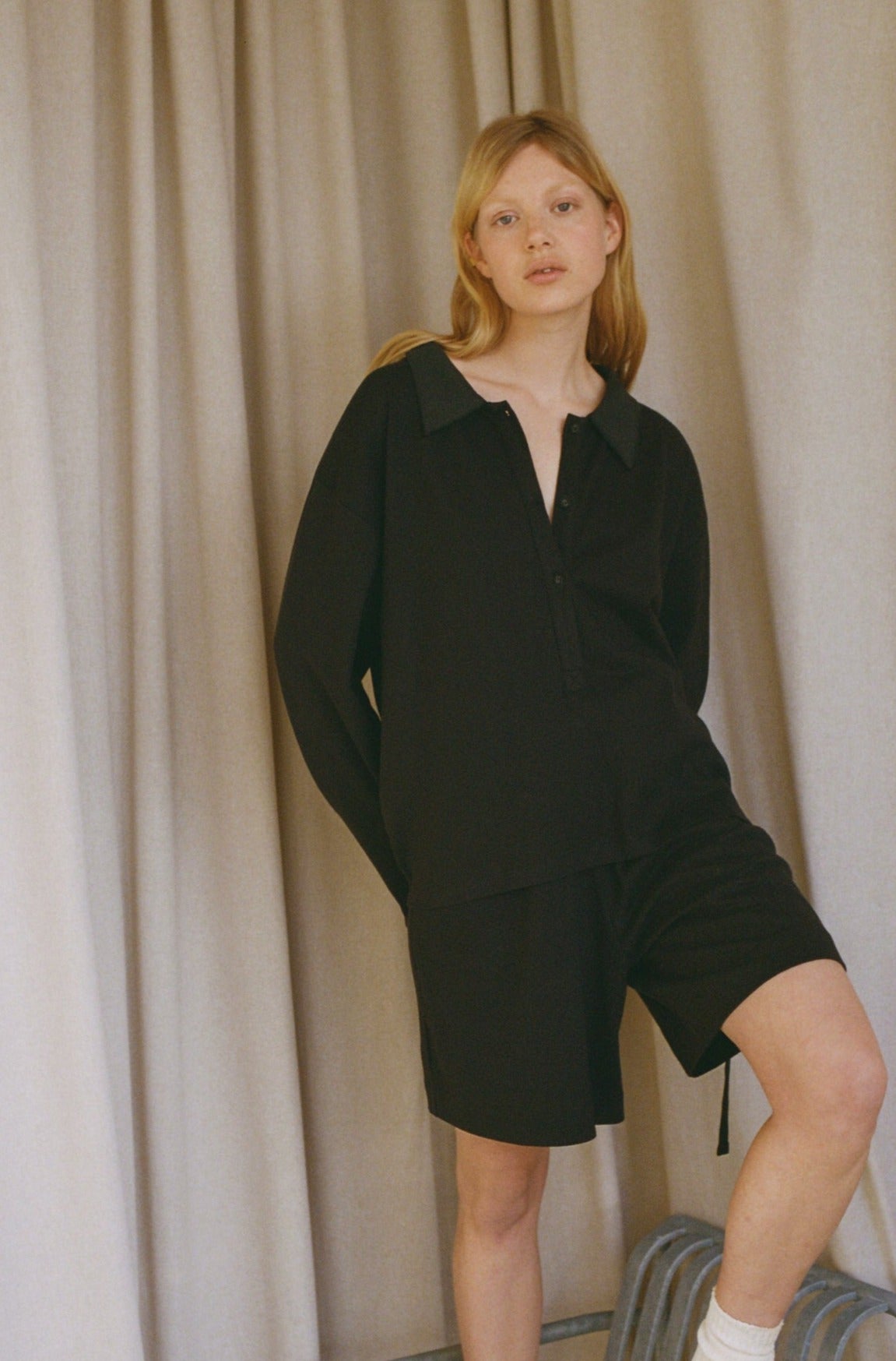 Female model wearing the jersey short - black by Deiji Studios against plain background