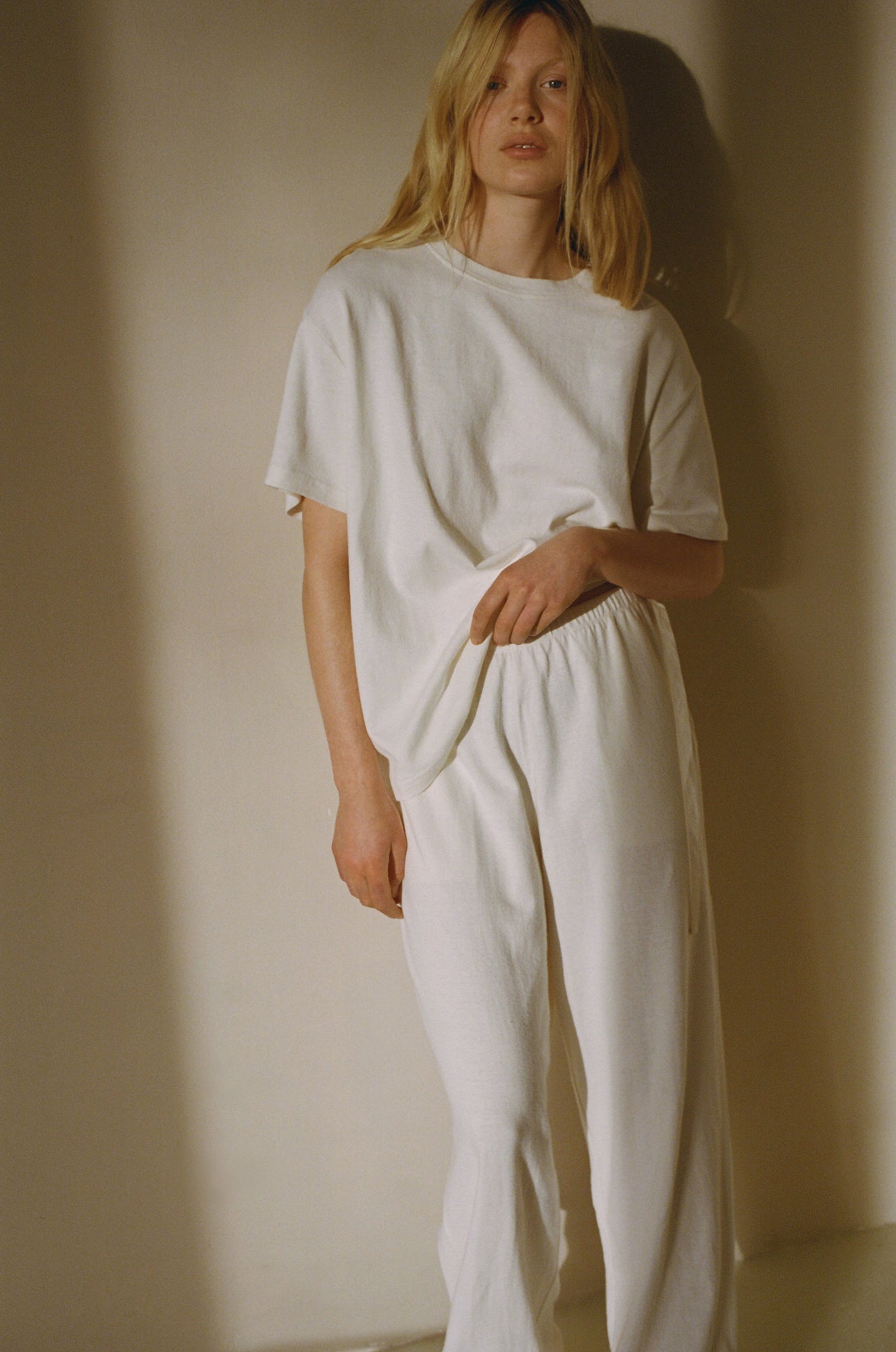 Female model wearing the jersey pant - bone by Deiji Studios against plain background
