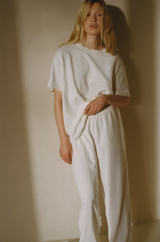 Female model wearing the jersey pant - bone by Deiji Studios against plain background