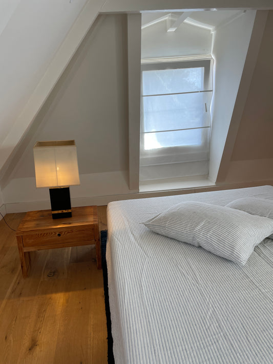 Light room with queen bed topped with Sheets - River Stripe by Deiji Studios