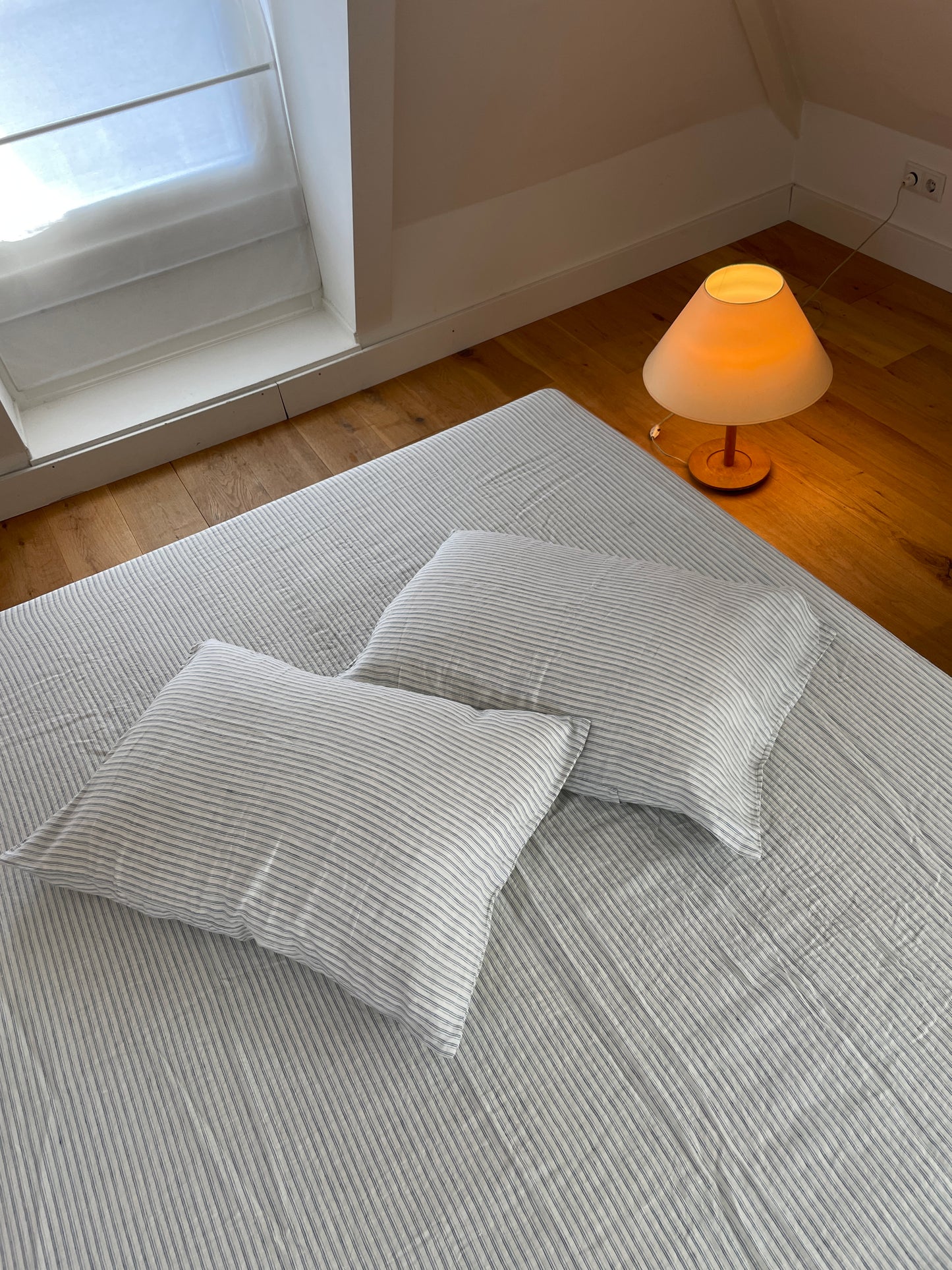 Light room with queen bed topped with Sheets - River Stripe by Deiji Studios