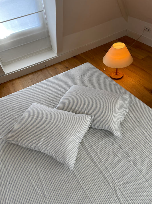 Light room with queen bed topped with Sheets - River Stripe by Deiji Studios