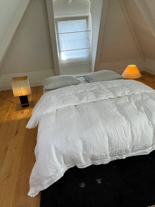 Light room with queen bed topped with Sheets - River Stripe by Deiji Studios