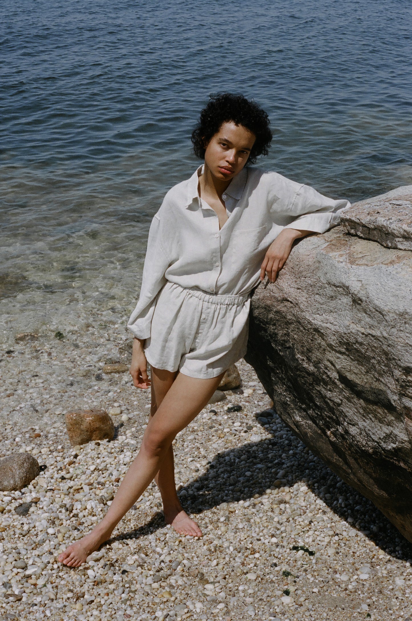 Female model on pebble beach wearing the 03 set - oatmeal by Deiji Studios