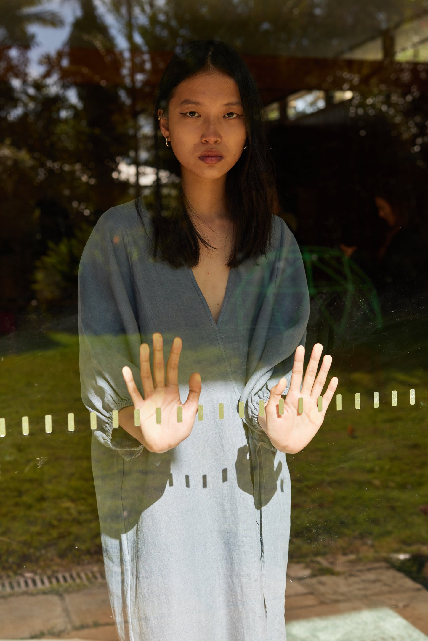 Female model wearing The Crease Bind Dress - Air by Deiji Studios against plain background