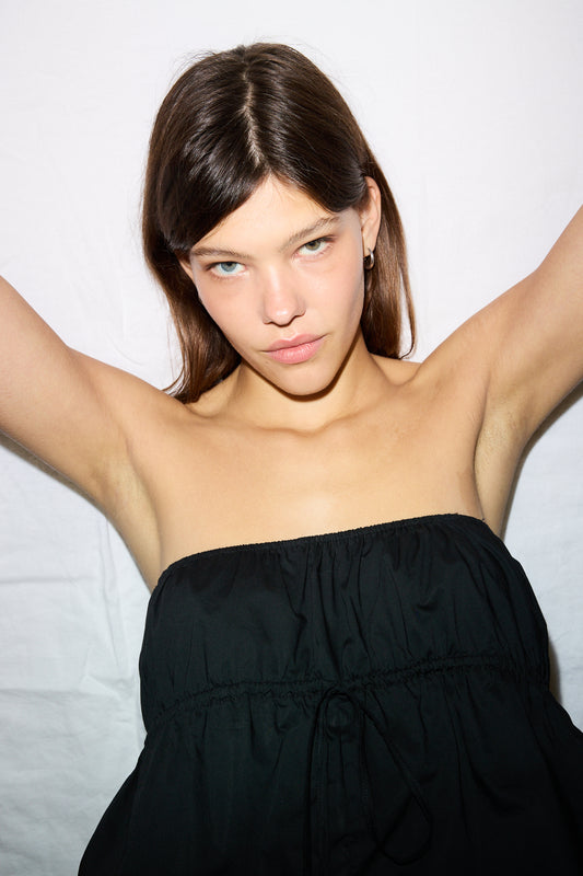 Female model wearing the strapless cotton top - black by Deiji Studios against plain background