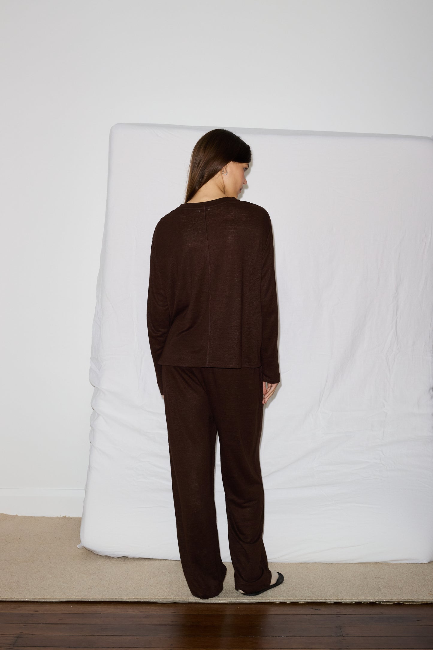 Female model wearing soft pant - chocolate by Deiji Studios against plain background