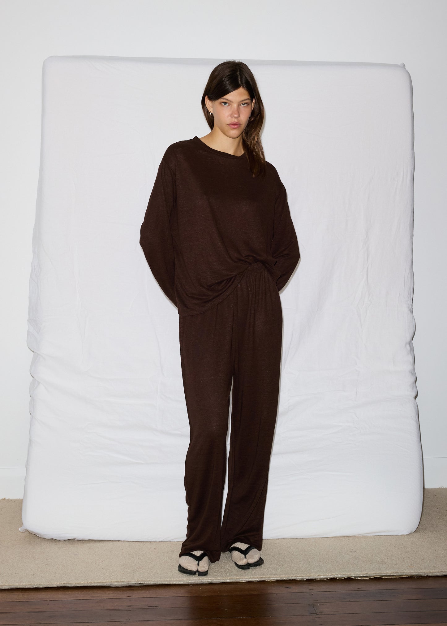 Female model wearing soft pant - chocolate by Deiji Studios against plain background