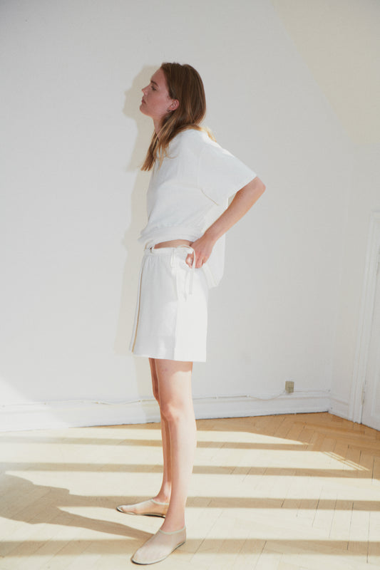 Female model wearing the jersey short - bone by Deiji Studios against plain background