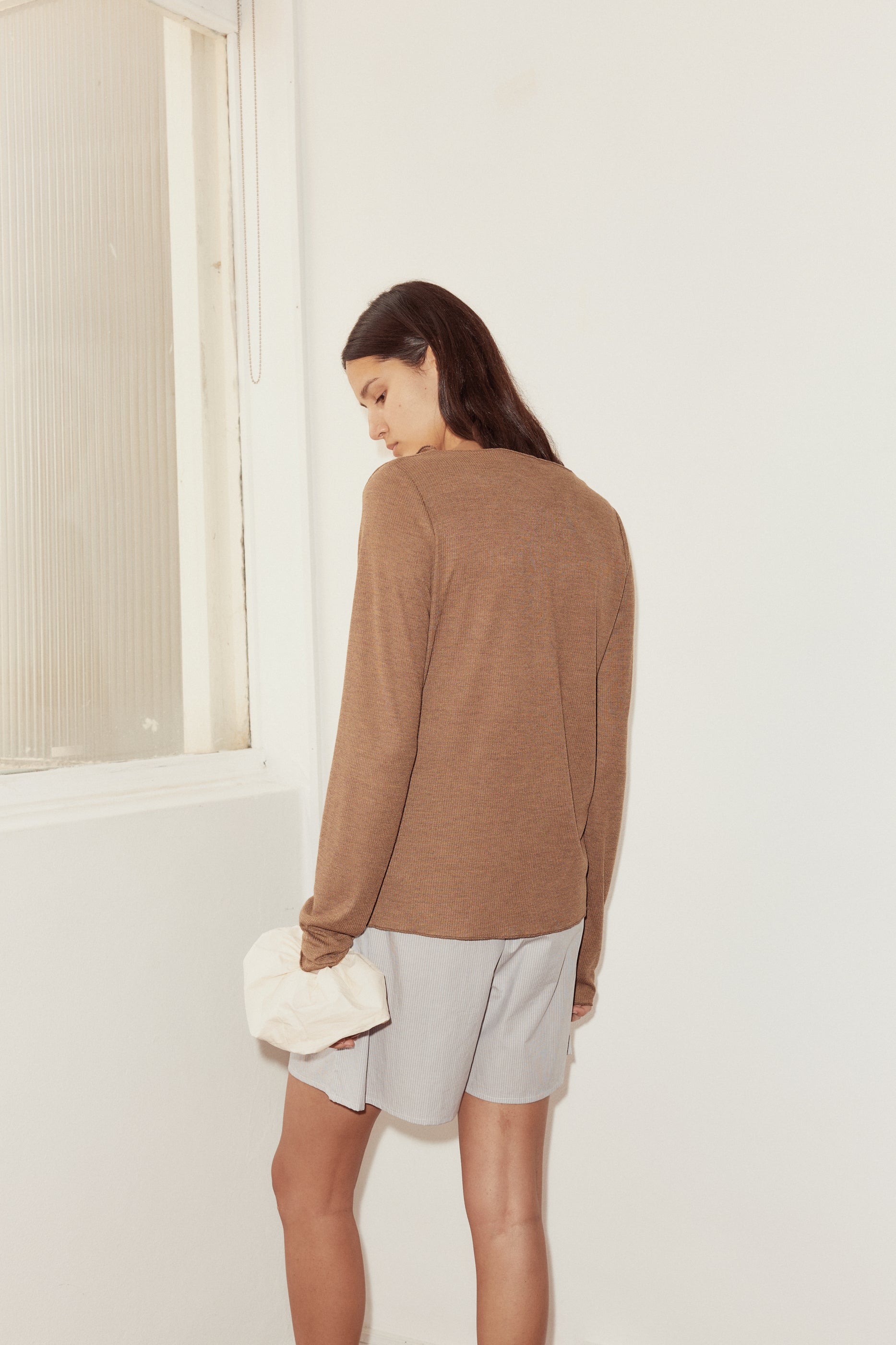 back shot of model wearing mid short in dream stripe and open long sleeve top in coffee. Short features relaxed fit and mid length.