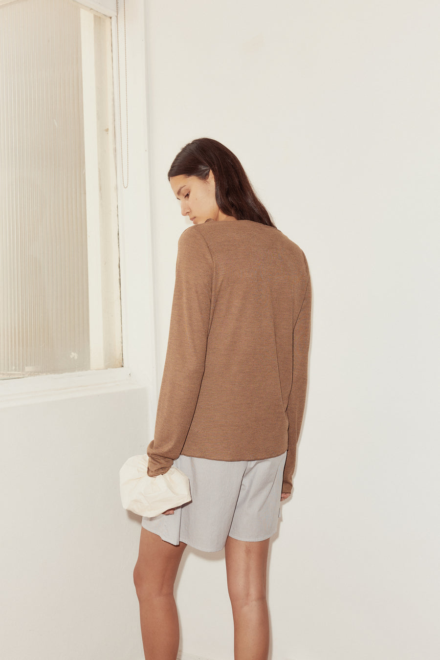 back shot of model wearing mid short in dream stripe and open long sleeve top in coffee. Short features relaxed fit and mid length.