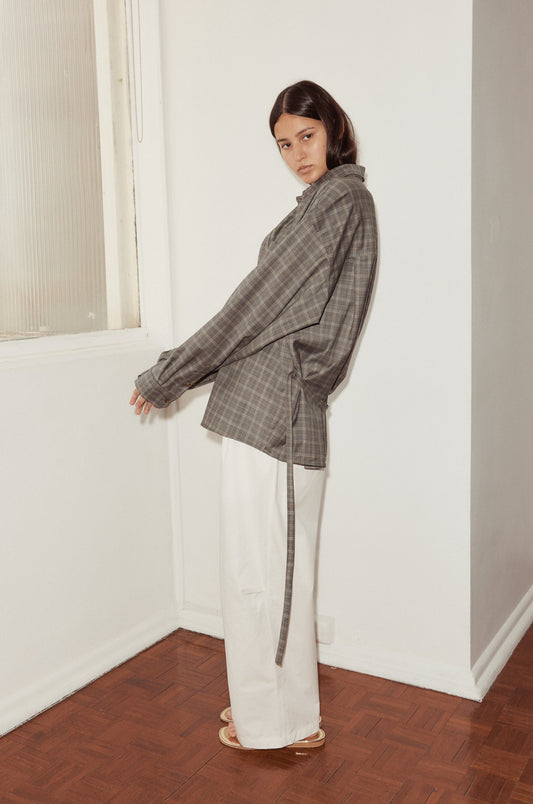 Mid shot of female model wearing the Wool Shirt in Everyday Check by Deiji Studios, styled with the Bartack Pant in white. Shirt features dropped shoulder with dropped back yoke for a relaxed fit, elongated sleeve with button cuff.