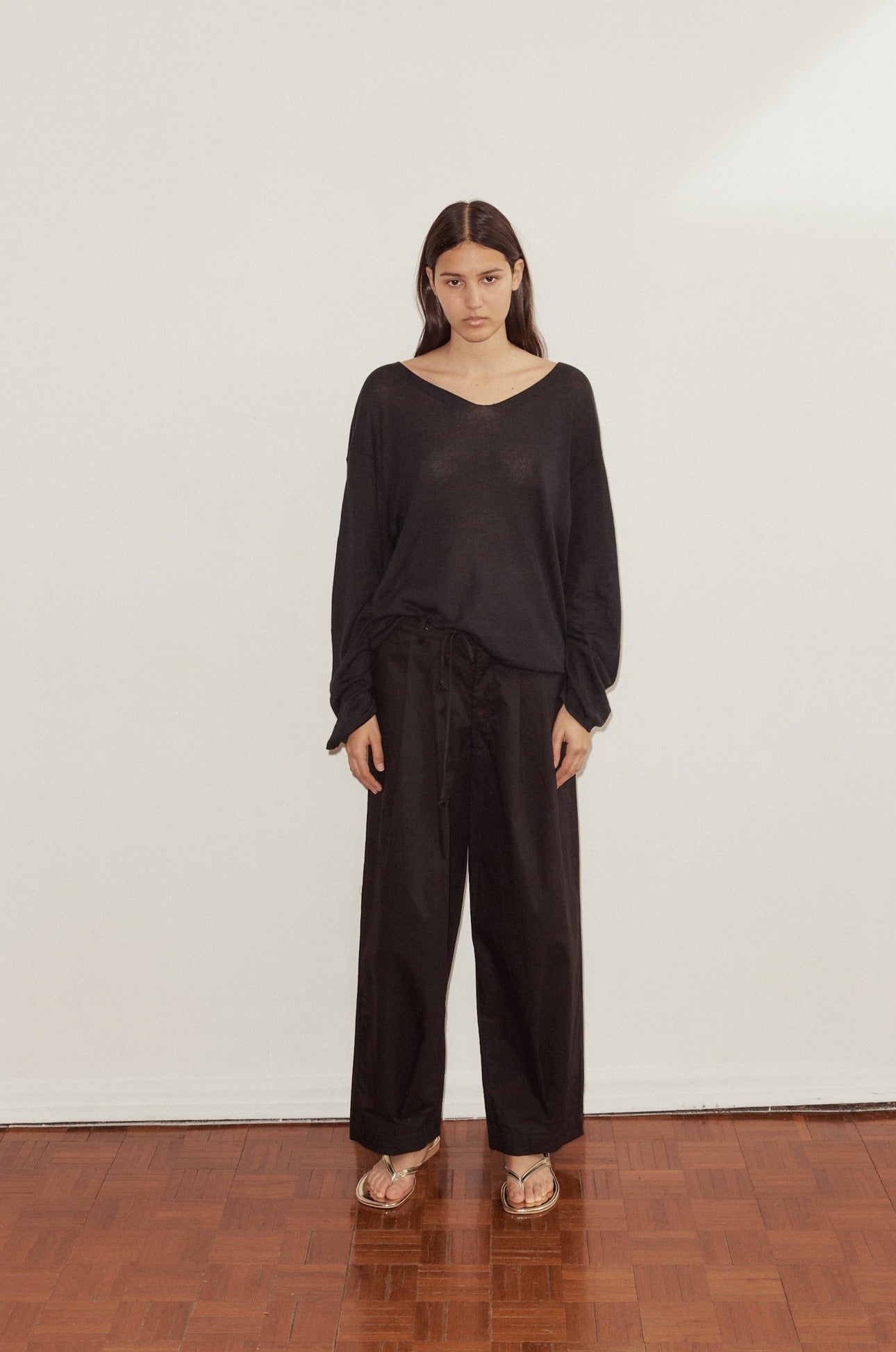 Female model wearing Loose Long Sleeve Knitted Top - Black by Deiji Studios against plain background