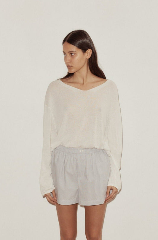 Female model wearing Loose Long Sleeve Knitted Top - White by Deiji Studios against plain background