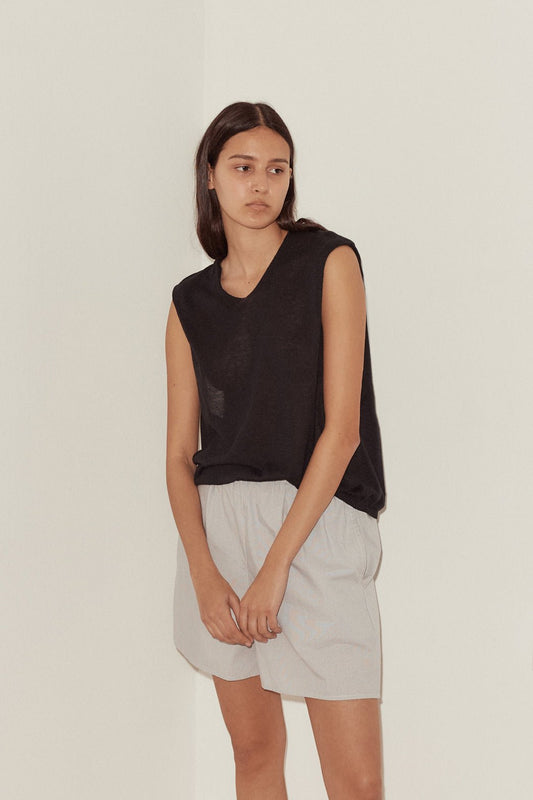 Female model wearing Loose Knitted Vest - Black by Deiji Studios against plain background