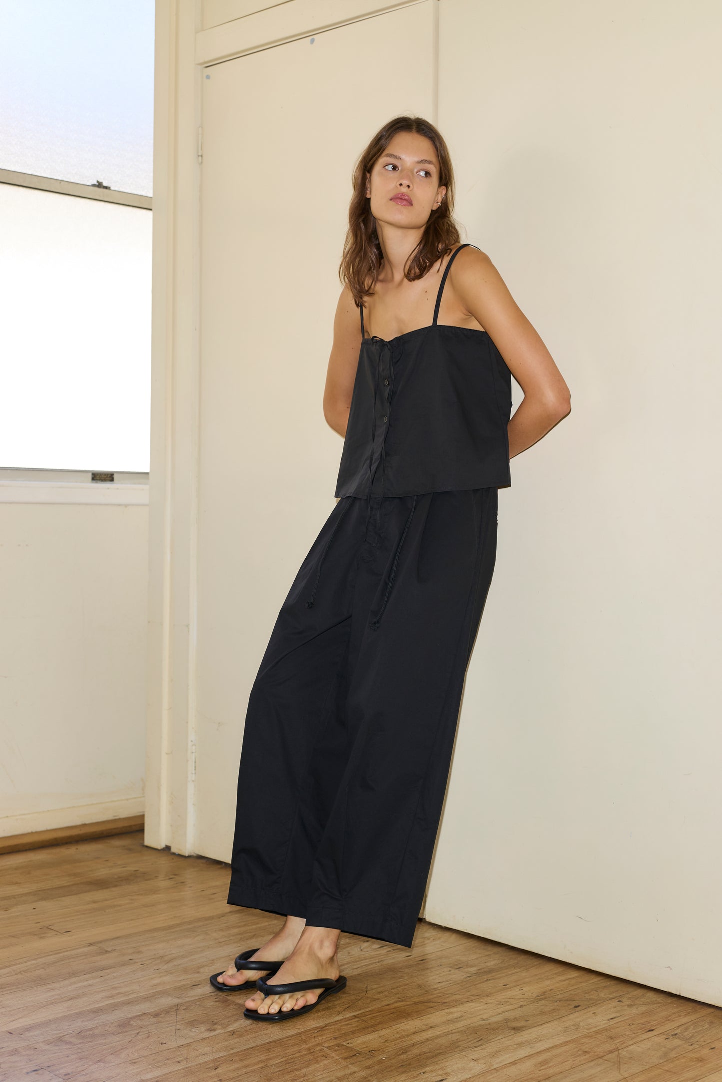 Female model wearing The Cotton Pant - Black by Deiji Studios against plain background