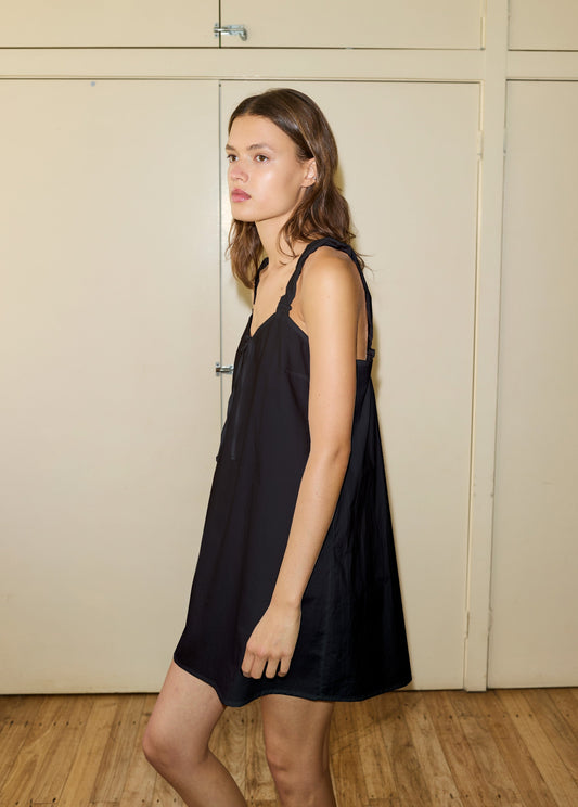 Female model wearing The Cotton Slip - Black by Deiji Studios against plain background