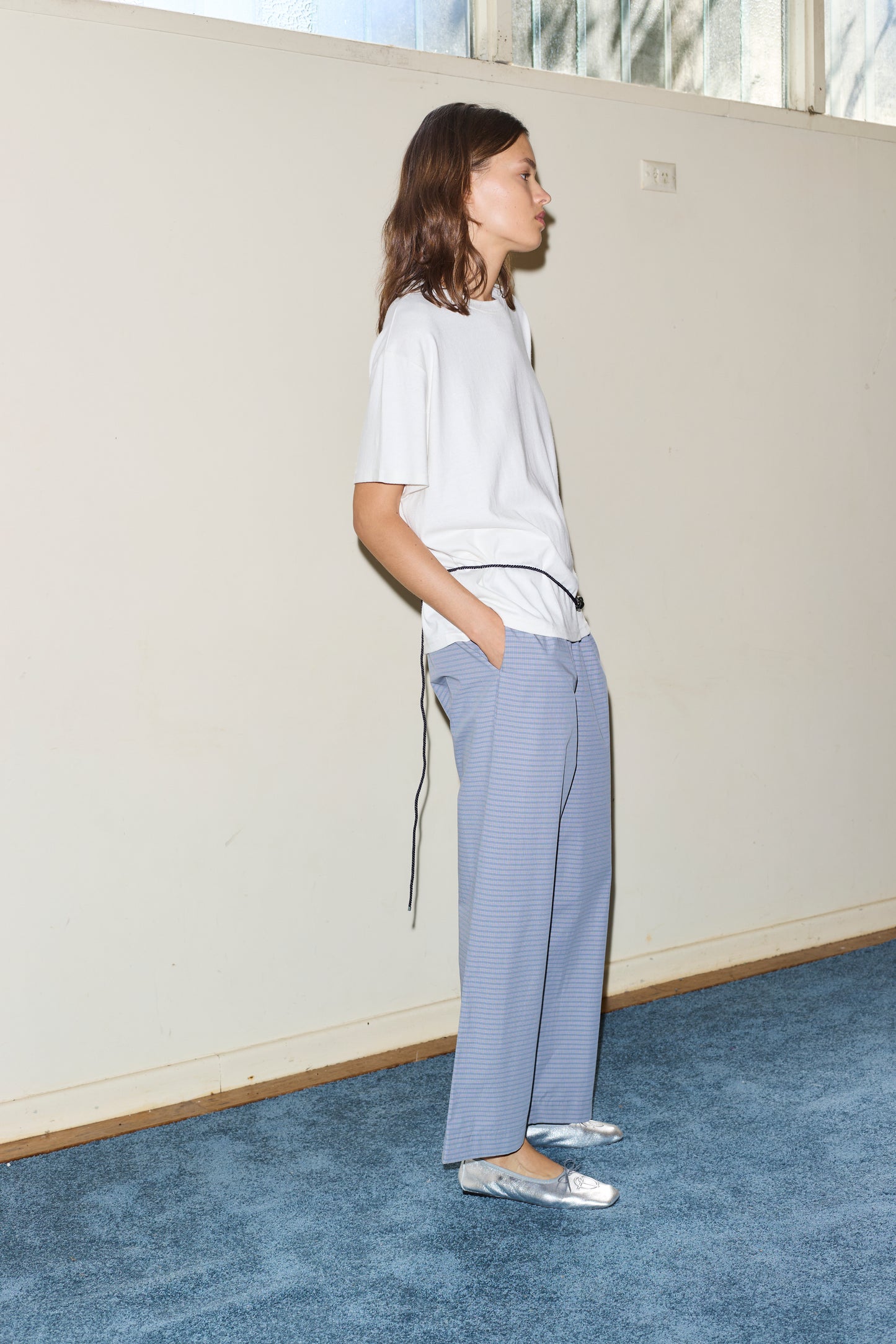 Female model wearing the ease trouser - pillow check by Deiji Studios against plain background