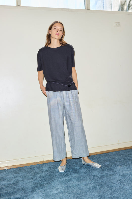 Female model wearing the ease trouser - field check by Deiji Studios against plain background