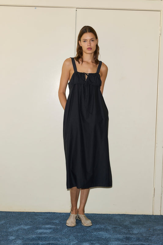 Female model wearing The Ruched Tie Dress - Black by Deiji Studios against plain background