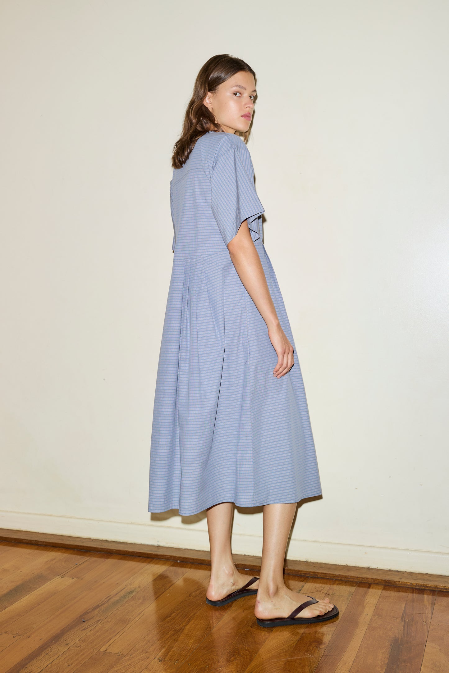Female model wearing The Square Sleeve Dress - Pillow Check by Deiji Studios against plain background