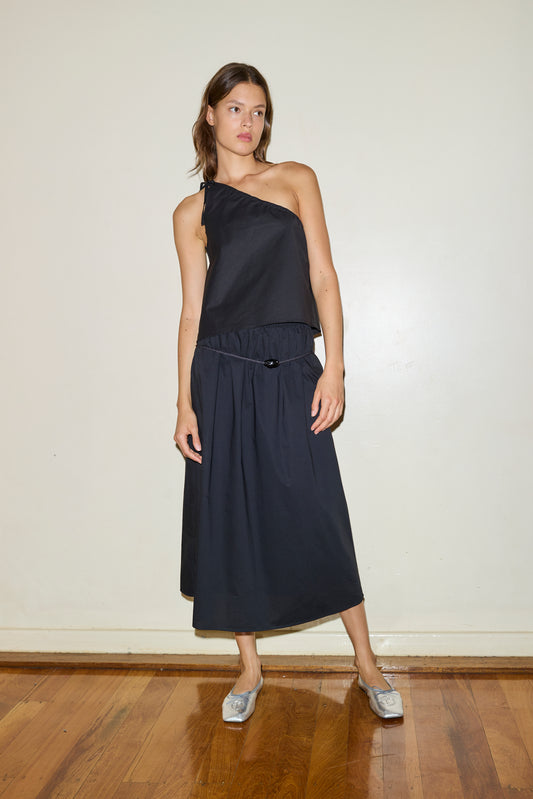 Female model wearing The Mid Cotton Skirt - Black by Deiji Studios against plain background