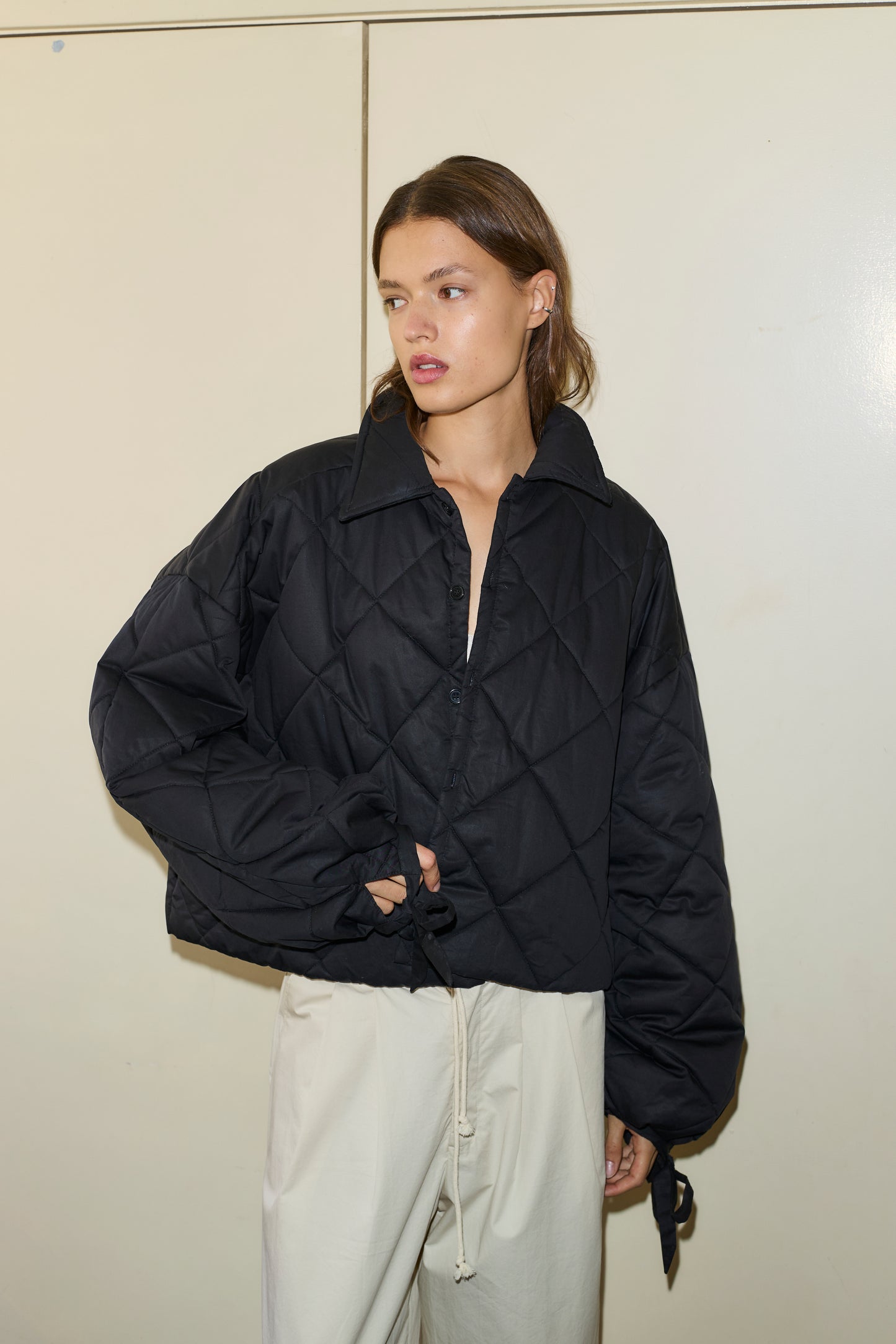 Female model wearing The Collared Quilt Coat - Black by Deiji Studios against plain background