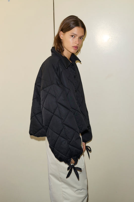 Female model wearing The Collared Quilt Coat - Black by Deiji Studios against plain background
