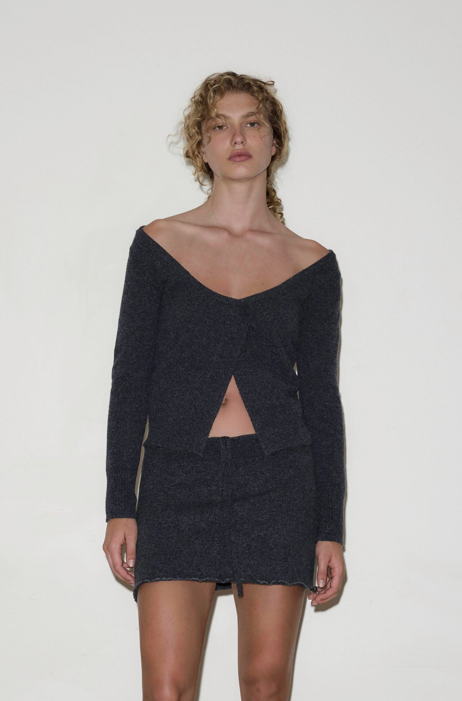 Female model wearing Asymmetric Knit Cardi - Charcoal by Deiji Studios against plain background