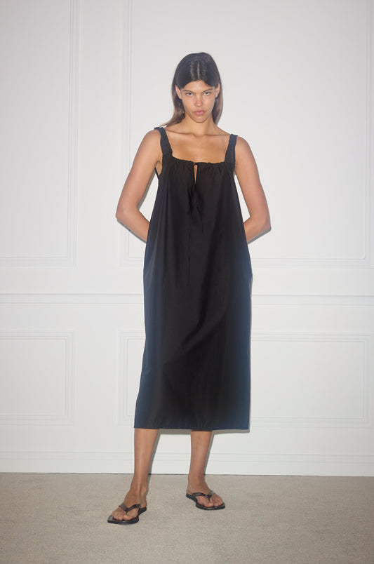 Female model wearing the paper dress - black by Deiji Studios against plain background