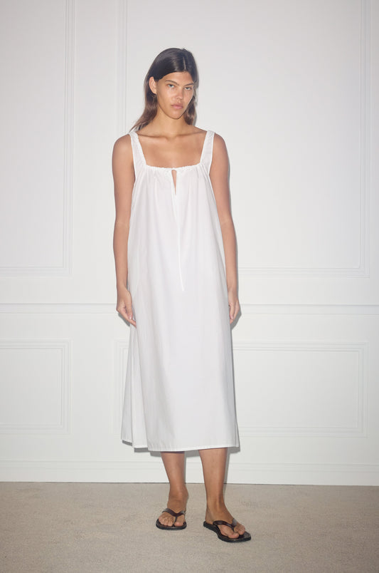 Female model wearing the paper dress - white by Deiji Studios against plain background