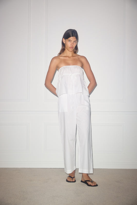 Female model wearing the ease trouser - white by Deiji Studios against plain background