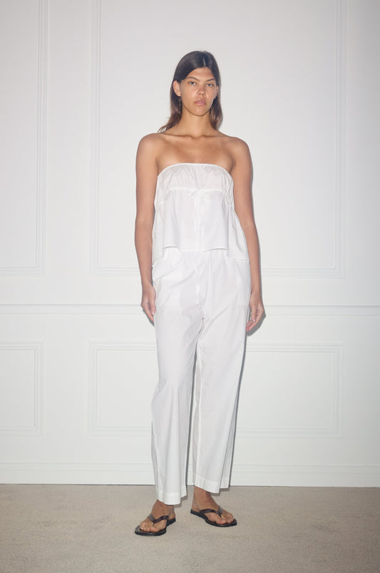 Female model wearing the strapless cotton top - white by Deiji Studios against plain background