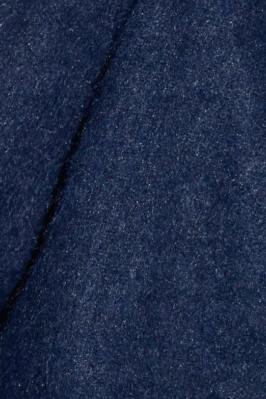 Close-up of the Belted Cardi - Navys dark blue, textured fabric made from recycled materials, highlighting a diagonal seam across the relaxed knit cardigan.