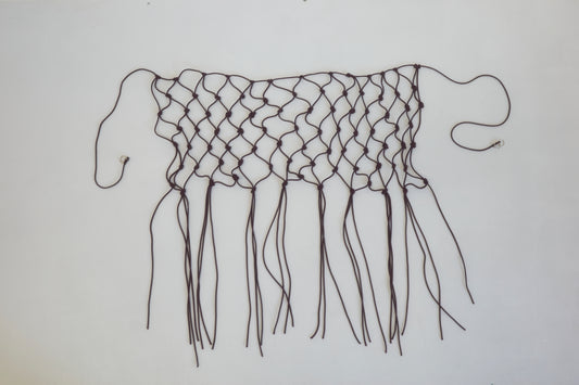 A handwoven black macramé belt made from recycled polyester, featuring loose ends and fringes, displayed flat on a white background.