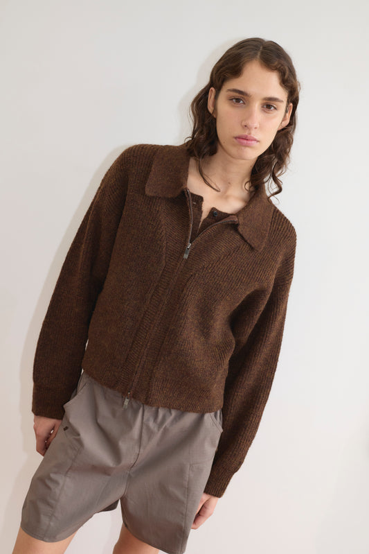 A person with wavy brown hair wears the Double Layer Cardigan - Brown from Deiji Studios and light gray shorts, standing against a plain white background and looking at the camera with a neutral expression.
