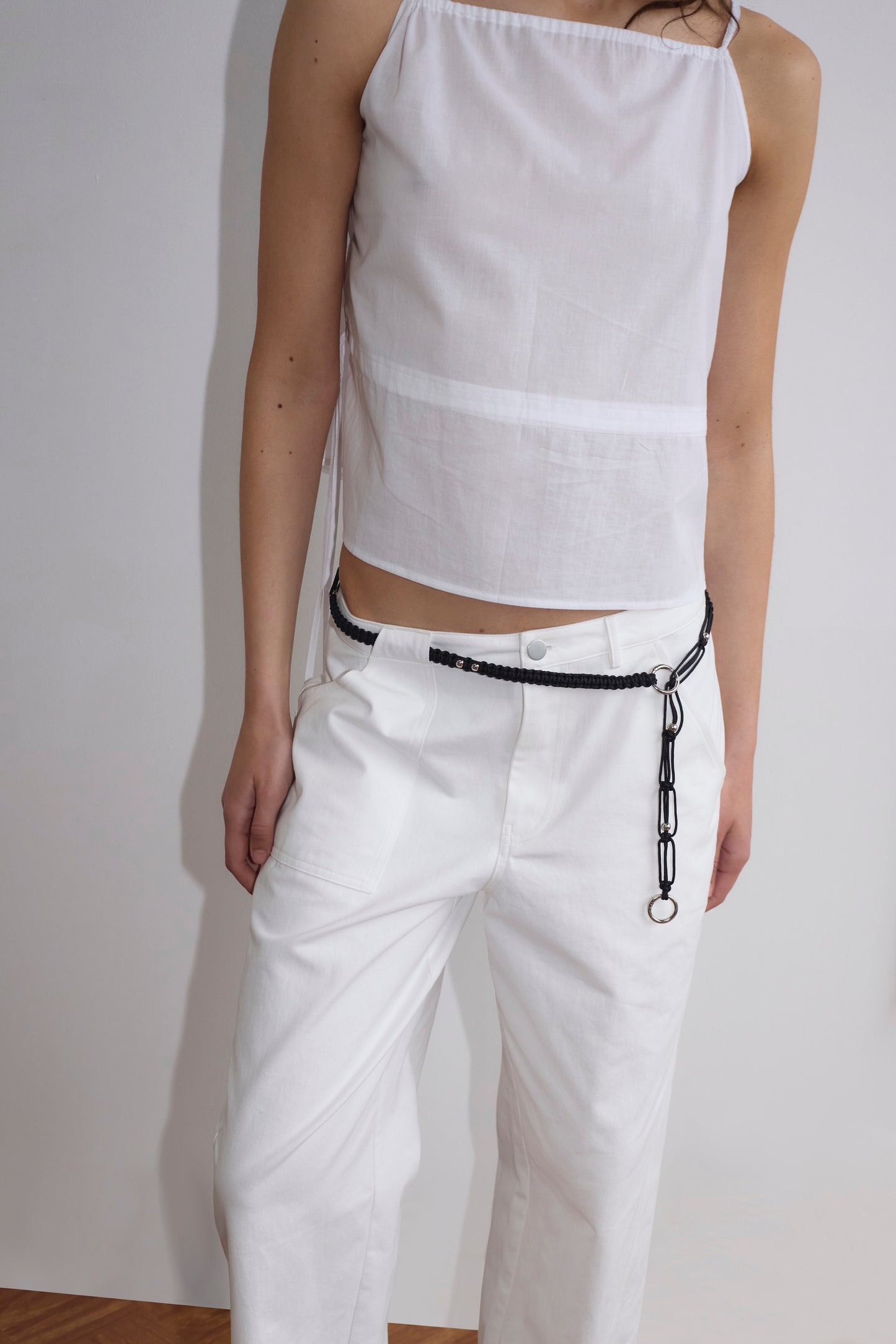A person wearing the Pocket Jean - White stands against a plain light-colored wall. Their face is out of frame.