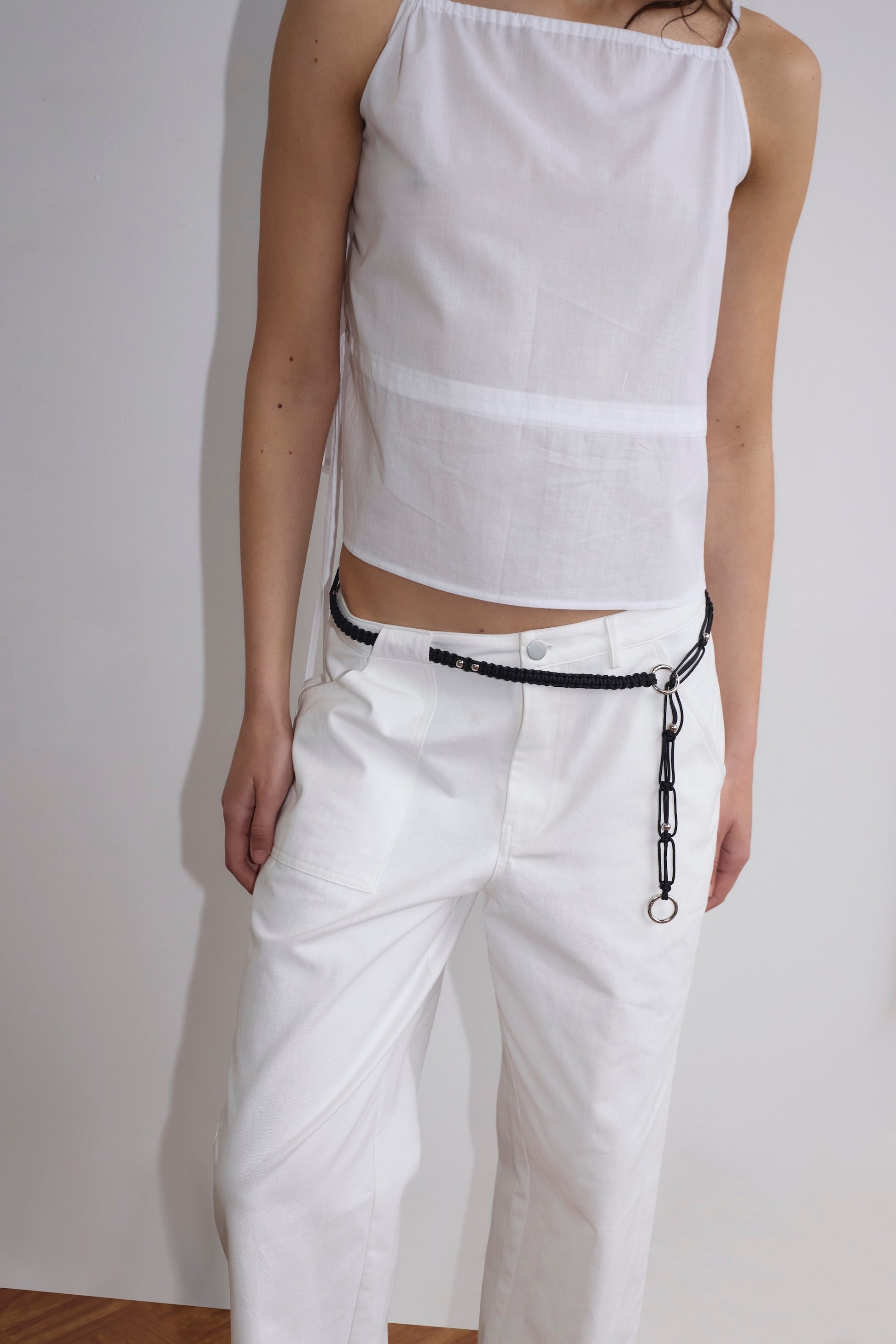 A person wearing the Pocket Jean - White stands against a plain light-colored wall. Their face is out of frame.