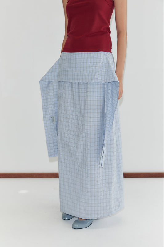 A person wears a red sleeveless top and a long, light blue plaid skirt featuring the Shirt Cuff Belt - Powder Check at the waist, standing against a white background in deiji studios style.