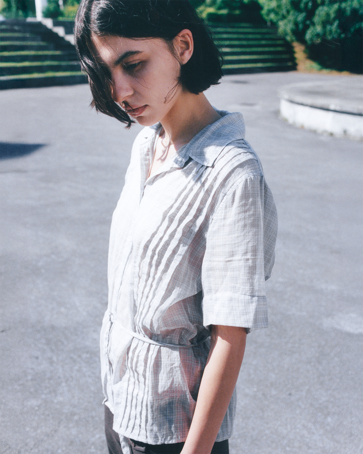 Model wearing sleeveless blouse in white