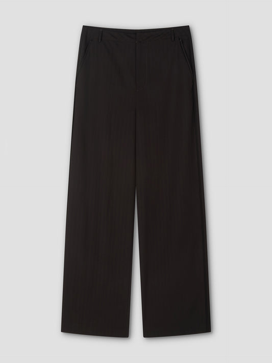 The Bind Pant - Charred Black Stripe features black wide-leg trousers with side pockets, belt loops, and a front zipper, shown against a plain light gray background.