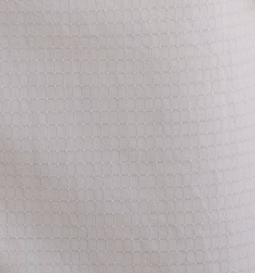 Close-up of Deiji Studios' Pocket Mini Dress - Bone Check, showcasing white organic cotton fabric with a subtle, evenly spaced square grid pattern that adds textured detail—perfect for this contemporary mini dress.